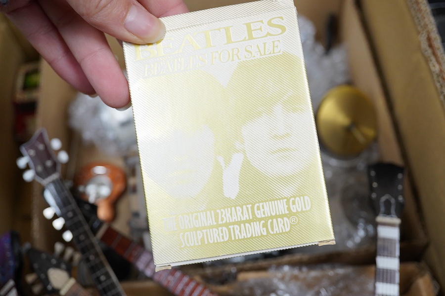 A collection of Beatles memorabilia including; models of a Beatles drum kit and eight miniature guitars and stands, each approx 25cm long, together with three boxed Corgi Beatles related models, including the Yellow Subm